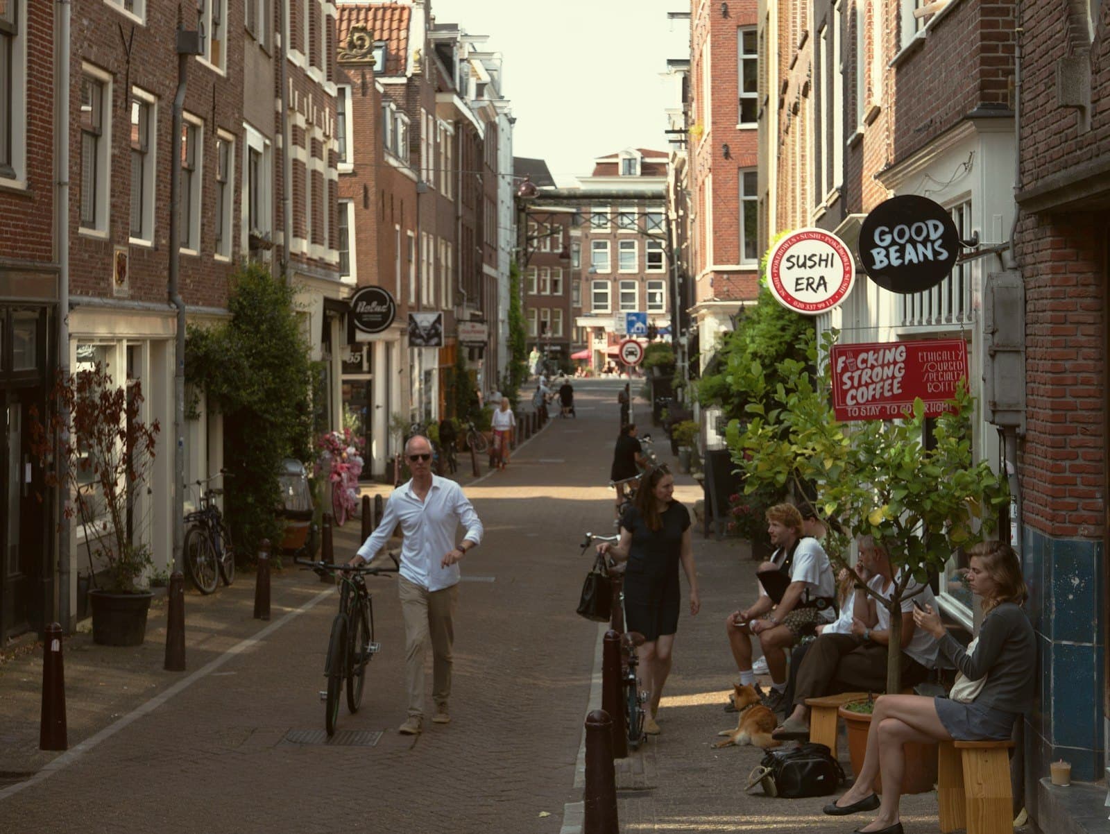 Drukke winkelstraat met kleine ondernemingen, terrassen en voorbijgangers