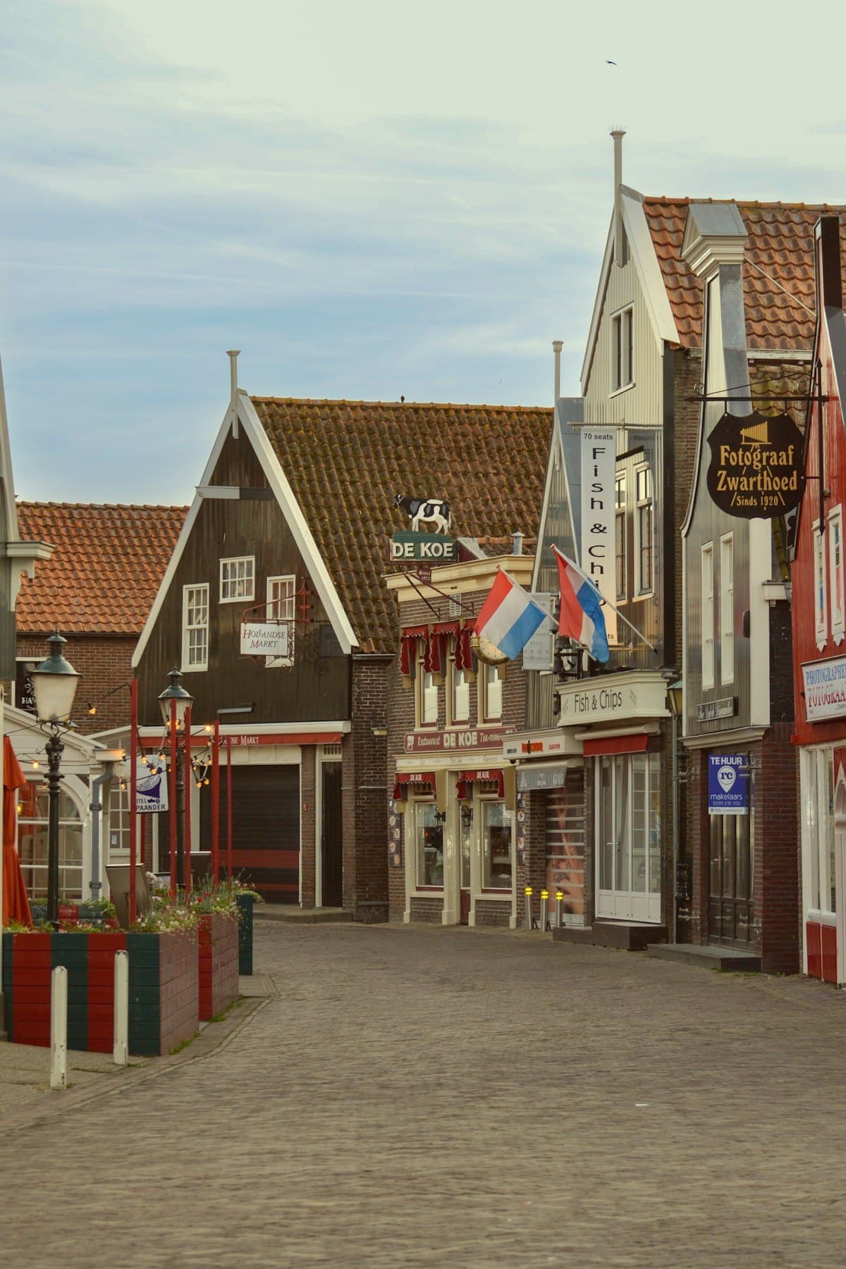 Nederlandse straat met historische gevels en vlaggen
